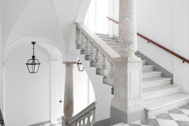 Scalinata in marmo bianco con colonne e lanterne.