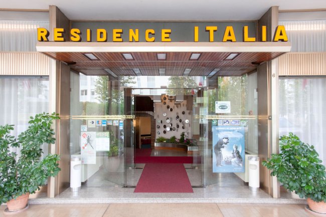 Ingresso del Residence Italia con tappeto rosso.