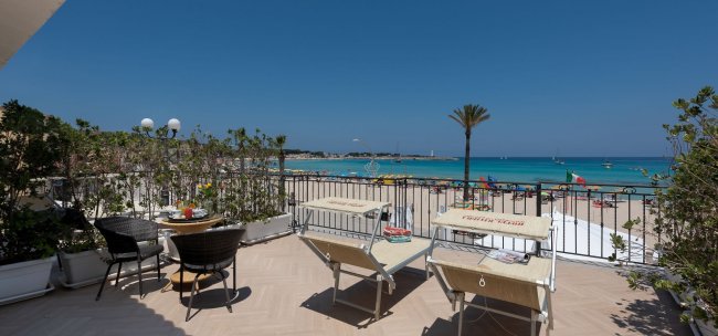Terrazza con vista sulla spiaggia e tavolini.
