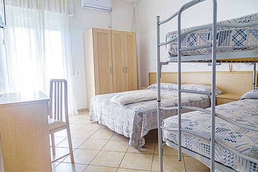 Camera con letto, scrivania e letto a castello.