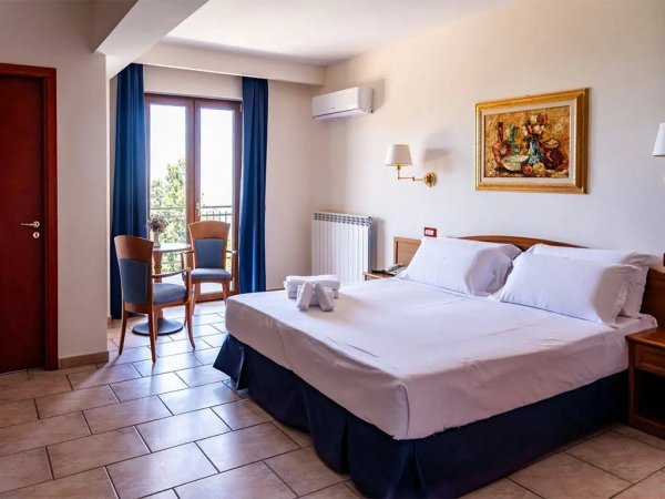 Camera matrimoniale con sedie vicino alla finestra.