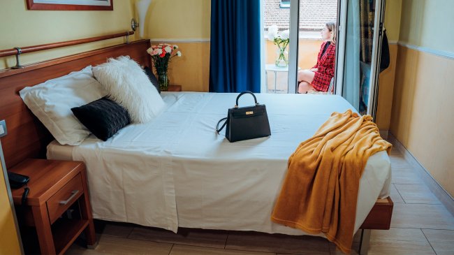 Stanza con letto, borsa e coperta gialla.