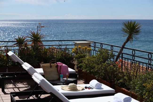 Lettini su terrazza con vista mare.