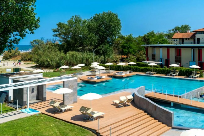 Piscina all'aperto con ombrelloni e lettini.