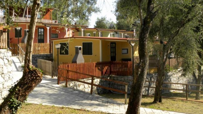 Casette colorate in un paesaggio alberato.