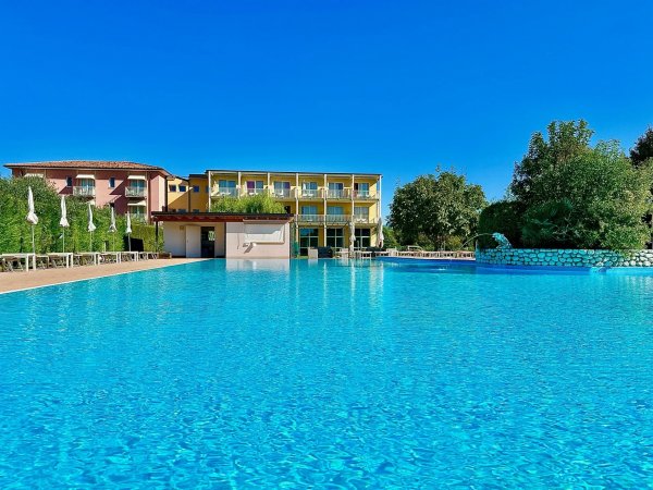 Piscina azzurra davanti a un edificio colorato.