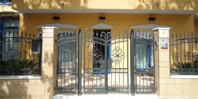 Recinzione e ingresso di un edificio giallo.