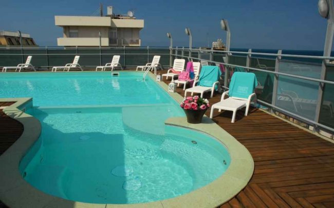 Piscina all'aperto con lettini e asciugamani.