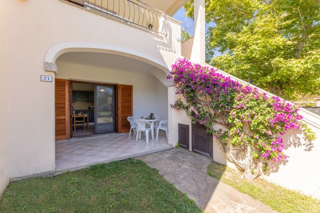 Veranda con tavolo bianco e fiori lilla.