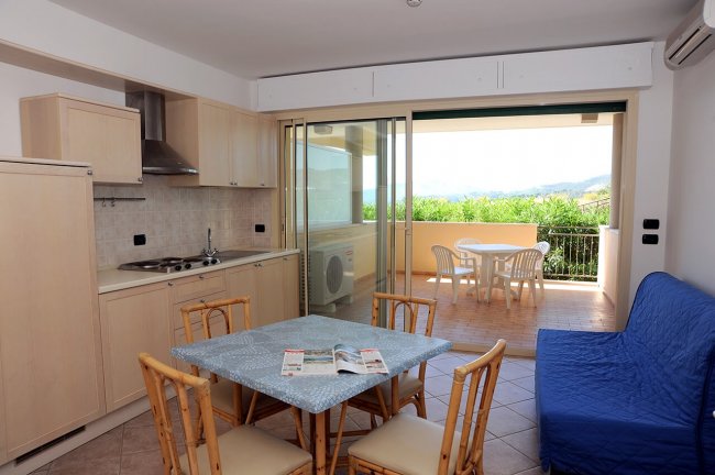 Cucina moderna con tavolo e terrazza esterna.