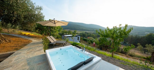 Una vasca idromassaggio con vista panoramica su colline verdi.