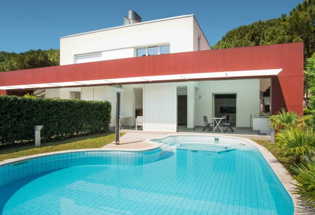 Piscina azzurra all'esterno di una villa moderna.