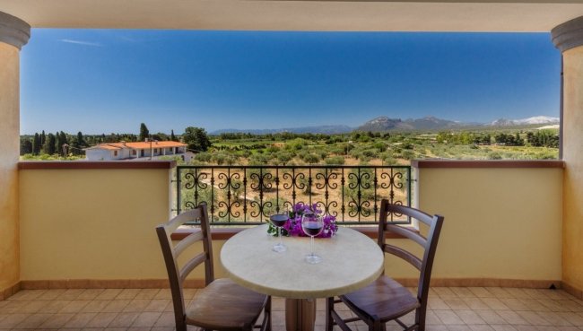 Terrazza con tavolo, sedie e vista montagna.