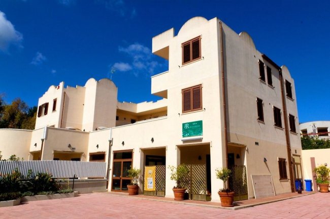 Edificio di hotel beige con finestre marroni.