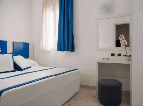 Camera con letto matrimoniale e dettagli blu.