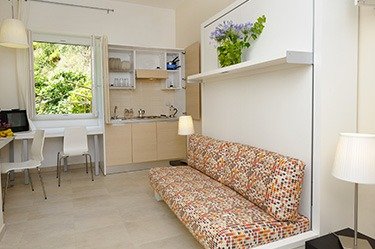 Cucina e soggiorno con divano a motivi geometrici.