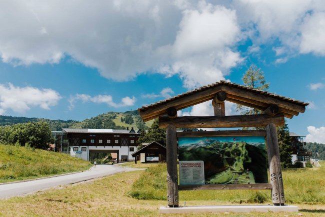 Strada di campagna con cartello informativo in legno.