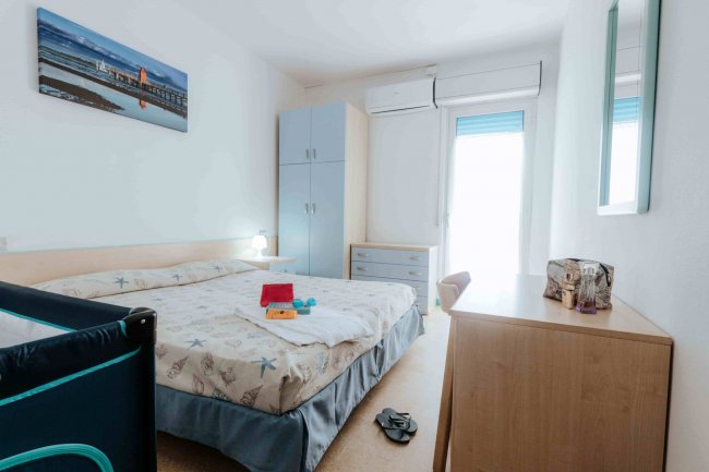 Camera con letto matrimoniale e arredamento semplice.