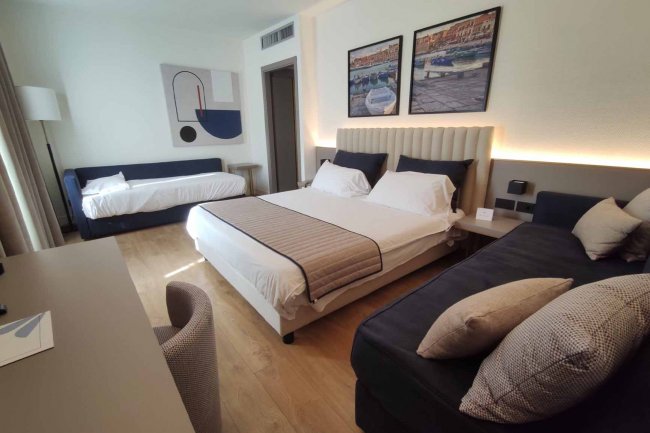 Camera moderna con letto matrimoniale e divano.