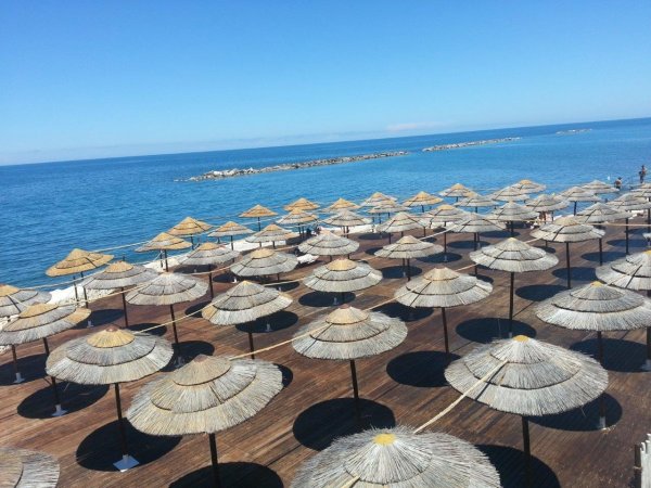 Ombrelloni di paglia su una piattaforma di legno.