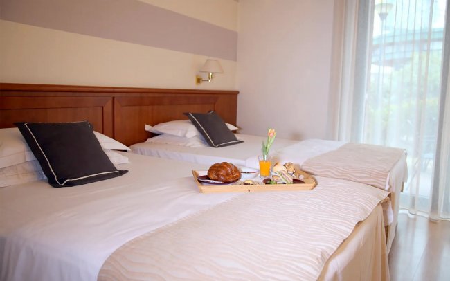 Due letti con vassoio colazione.