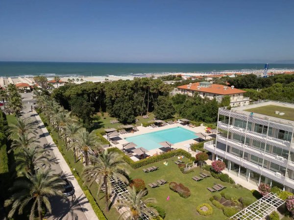 Vista aerea di hotel con piscina e mare.