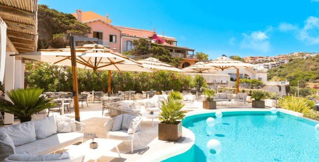 Piscina con sedie a sdraio e ombrelloni.