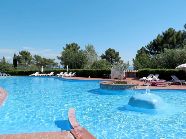 Piscina ampia con lettini e ombrelloni.