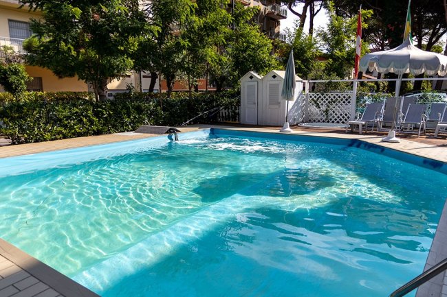 Piscina all'aperto con sedie a sdraio.