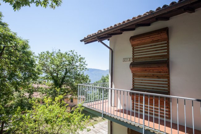 Balcone con vista su alberi e montagne.