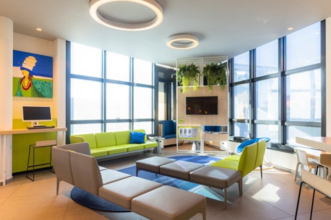 Salotto moderno con divani colorati e ampie finestre.