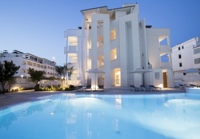 Edificio bianco con piscina illuminata.