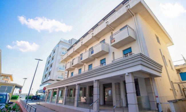 Edificio bianco a più piani con balconi.