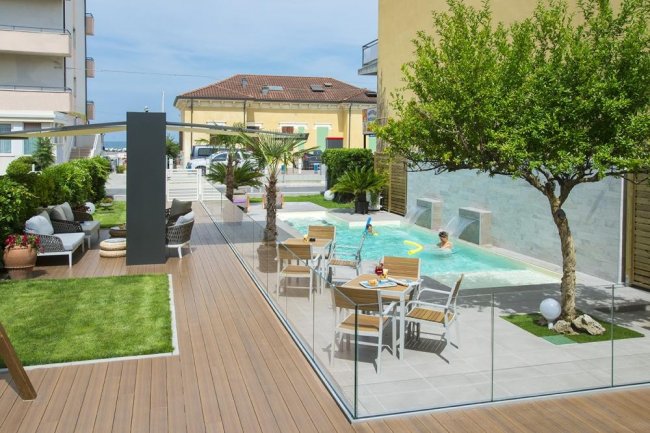 Area con piscina, tavoli e alberi.