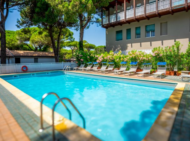Piscina all'aperto con lettini e ombrelloni.