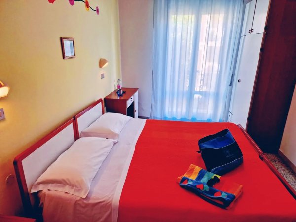 Letto matrimoniale con copriletto arancione.