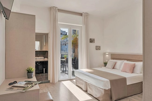 Camera da letto con balcone e bagno.