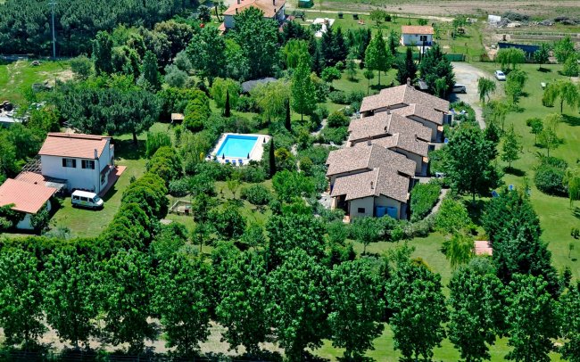 Complesso di case con piscina circondato da alberi.