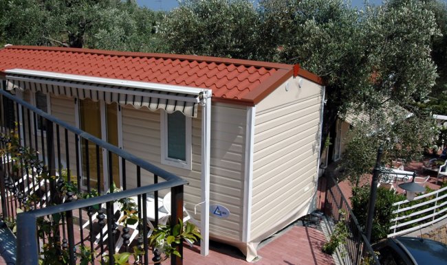 Casa mobile con tetto rosso e giardino.