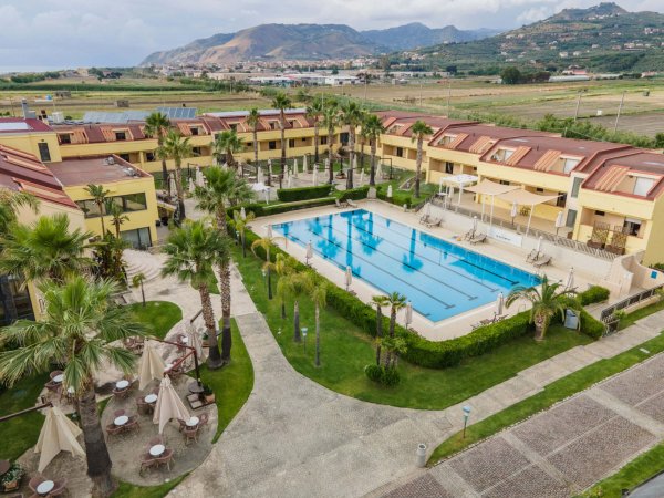 Resort con piscina e palme.