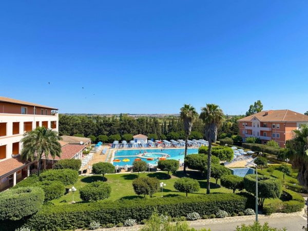 Vista dall'alto di una piscina circondata da verde.