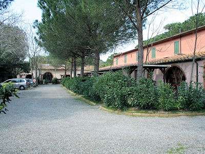 Edificio rosa con giardino e gravi percorsi.