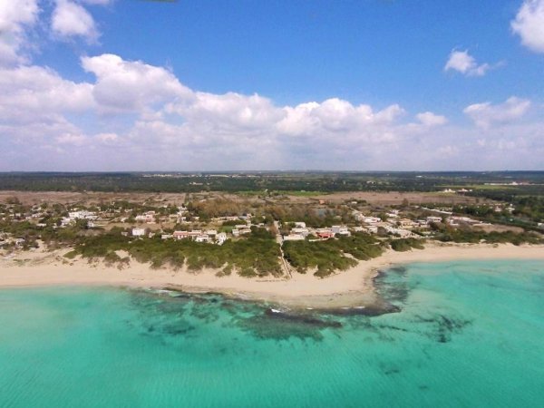 Veduta aerea di una spiaggia con acque turchesi.