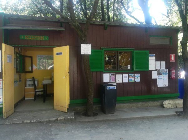 Chiosco di legno con porte e finestre verdi.