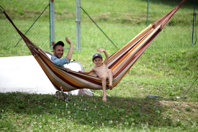 Uomo e bambino su un'amaca colorata.