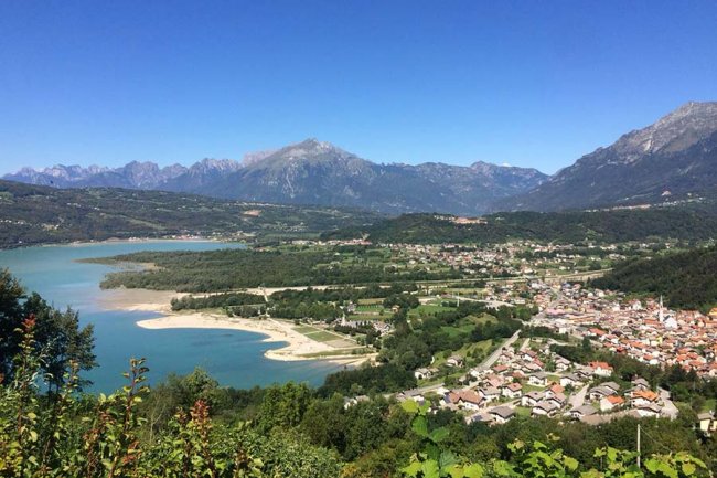 Panorama di un lago e montagne con un villaggio.