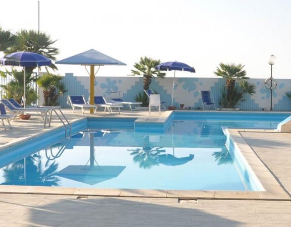 Piscina all'aperto con ombrelloni blu.