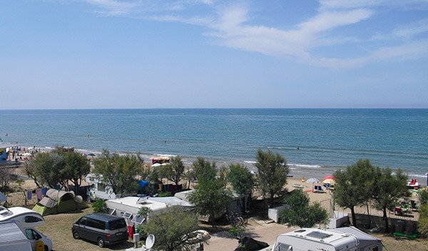 Spiaggia con campeggio e roulotte vicino al mare.