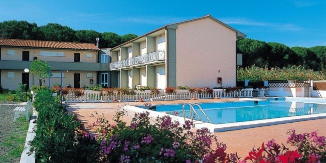 Esterno di una struttura con piscina e giardino.