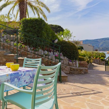 Tavolo all'aperto con sedie, vista giardino.